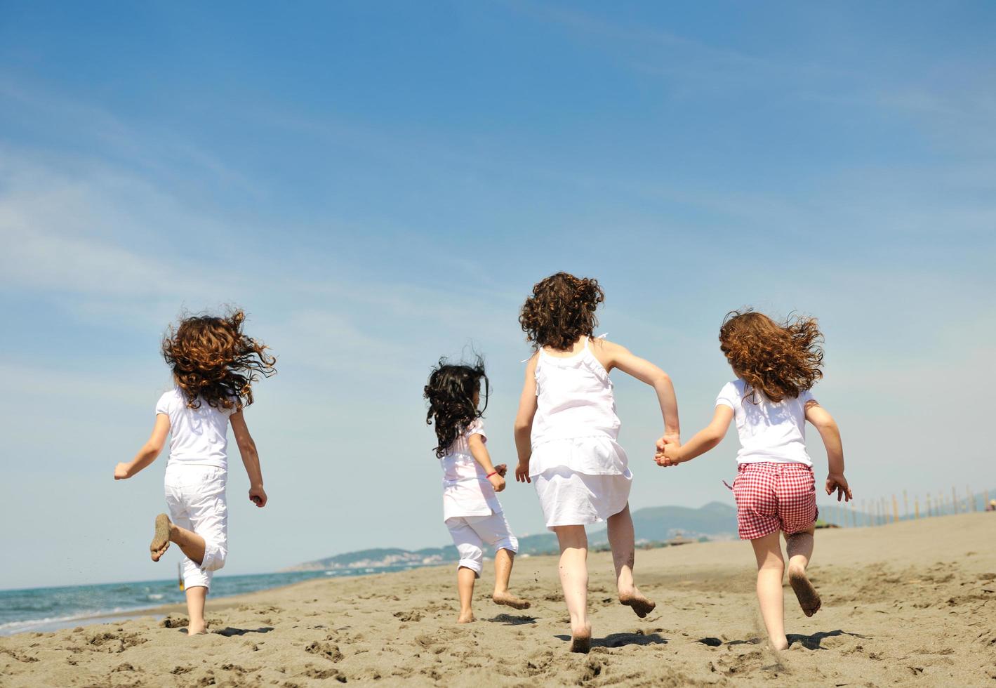 groupe d'enfants heureux jouant sur la plage photo