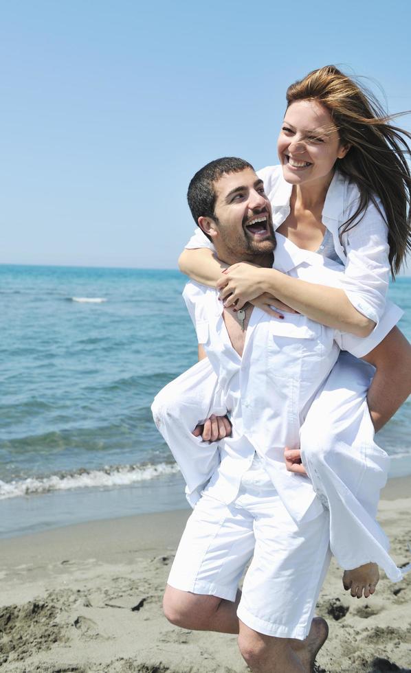 heureux jeune couple s'amuser sur la plage photo