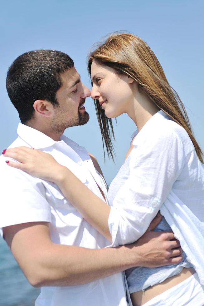 heureux jeune couple s'amuser sur la plage photo