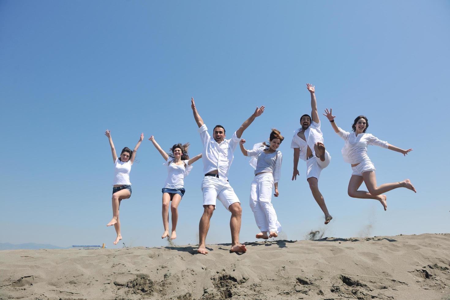 groupe de personnes heureuses s'amuser et courir sur la plage photo