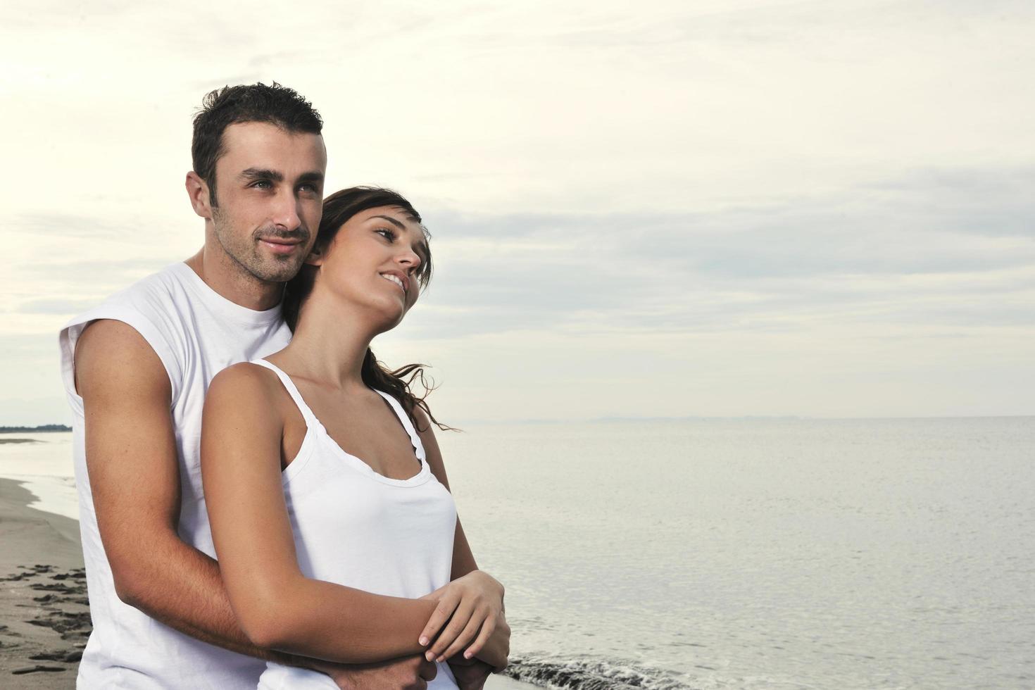 heureux jeune couple s'amuser sur la belle plage photo