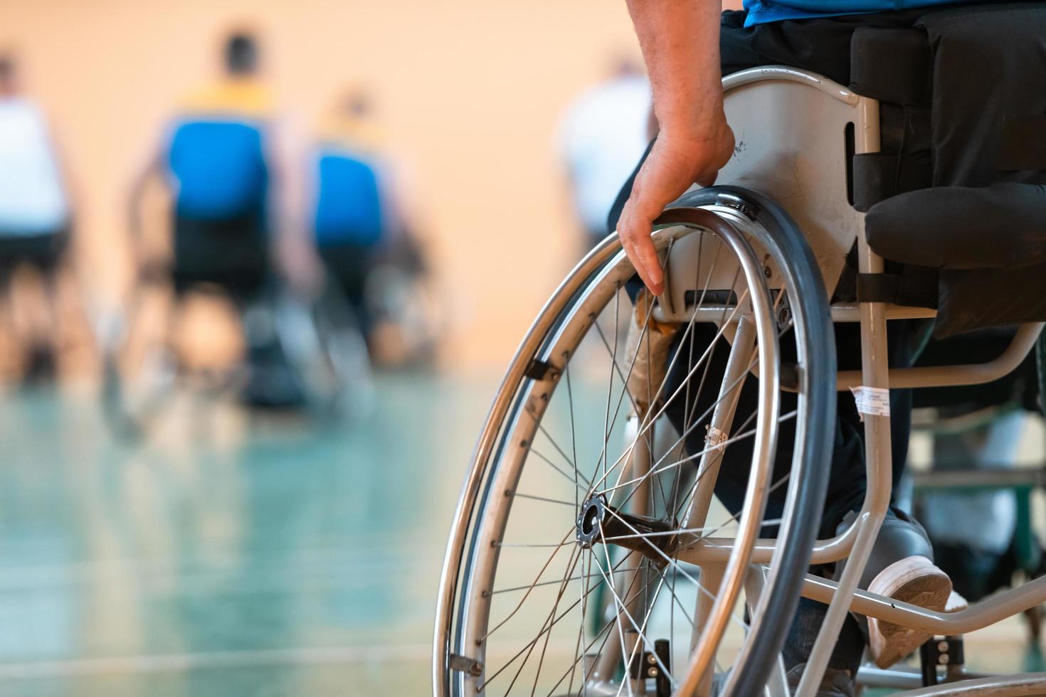 photo en gros plan de fauteuils roulants et d'anciens combattants handicapés jouant au basket-ball sur le terrain