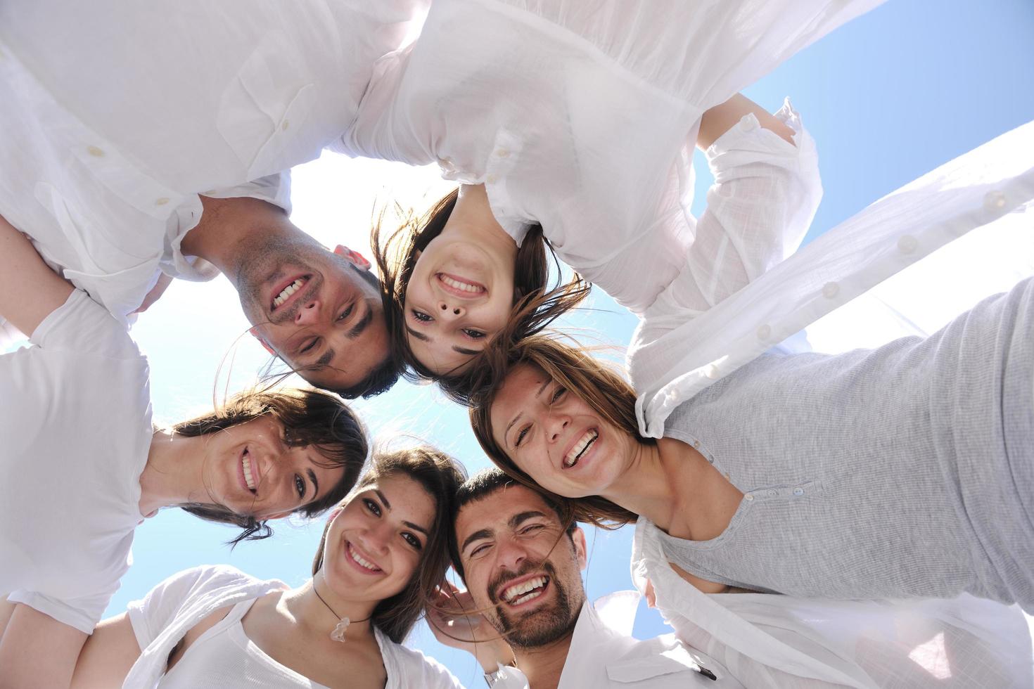 groupe de jeunes heureux en cercle à la plage photo