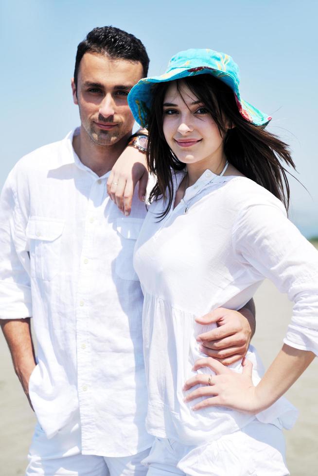 heureux jeune couple s'amuser sur la plage photo