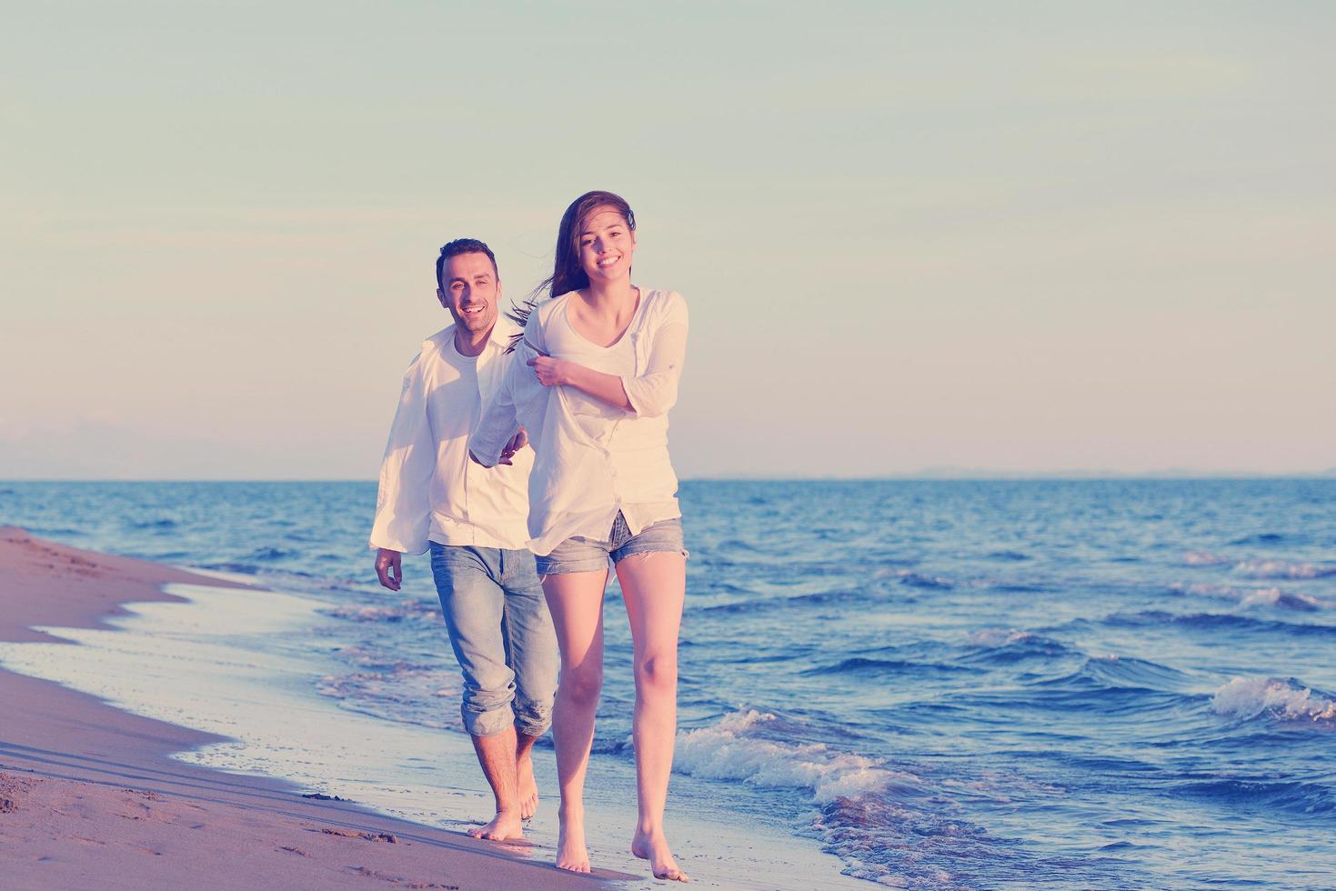 jeune couple sur la plage s'amuser photo