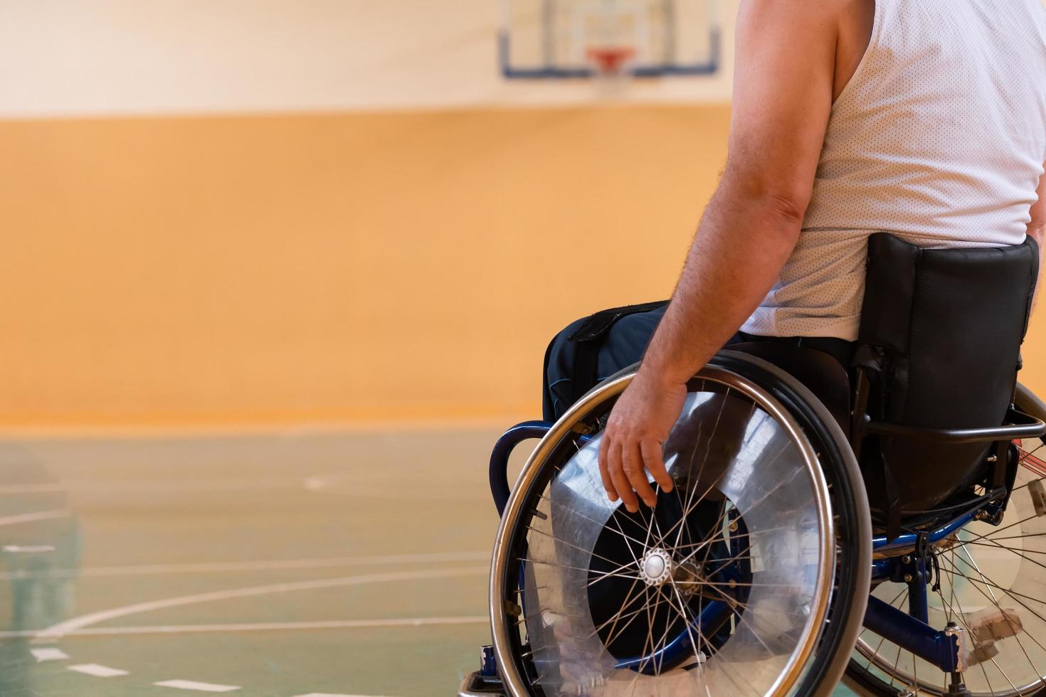 photo en gros plan de fauteuils roulants et d'anciens combattants handicapés jouant au basket-ball sur le terrain