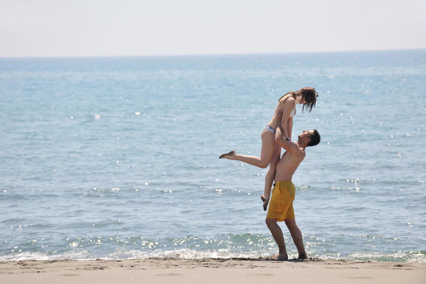 heureux jeune couple s'amuser sur la plage photo