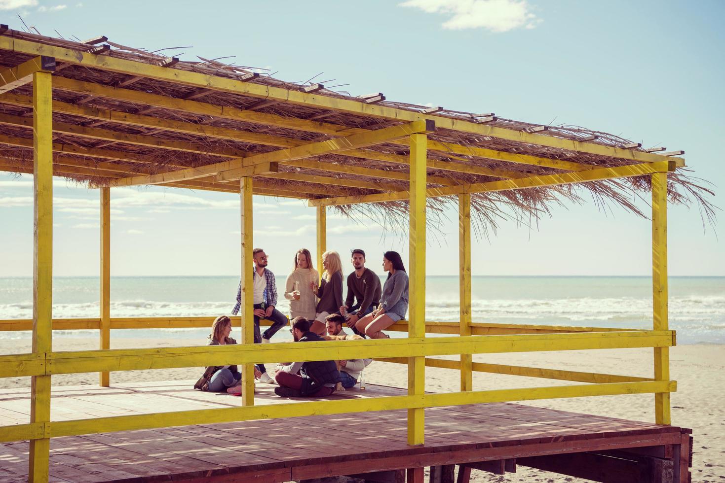 groupe d'amis s'amusant le jour de l'automne à la plage photo