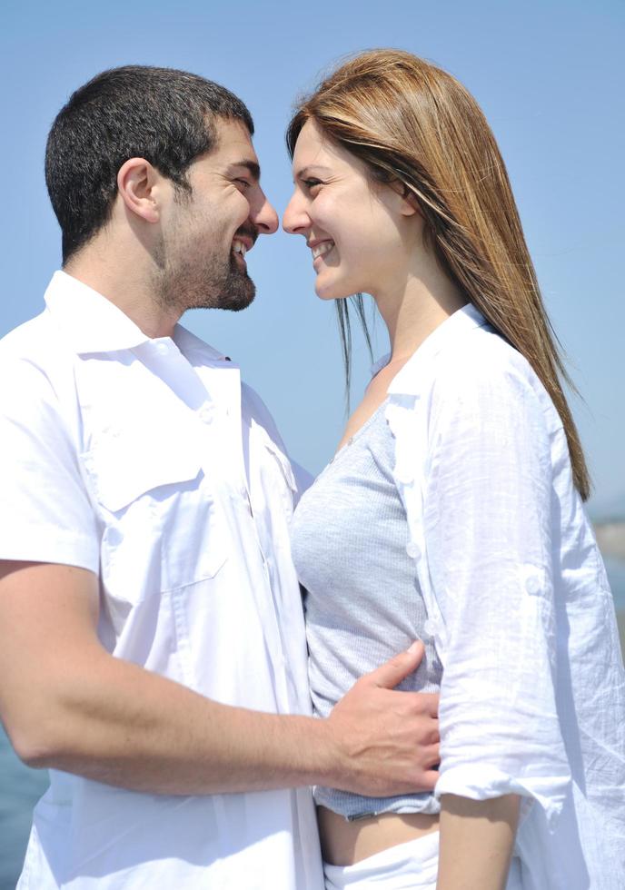 heureux jeune couple s'amuser sur la plage photo