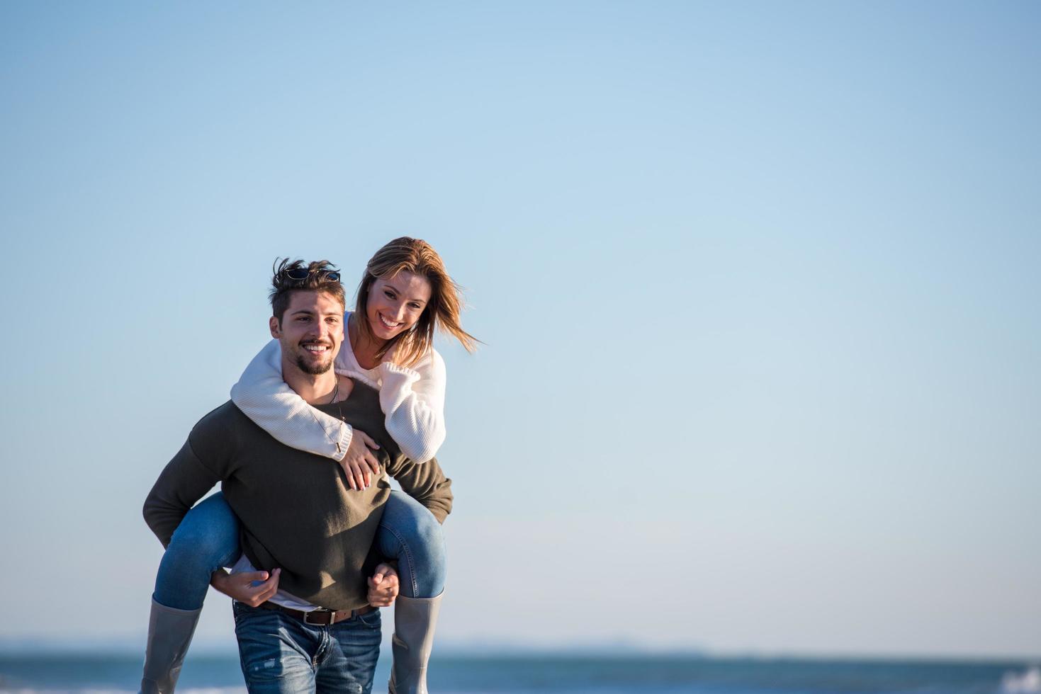 couple s'amusant à la plage en automne photo