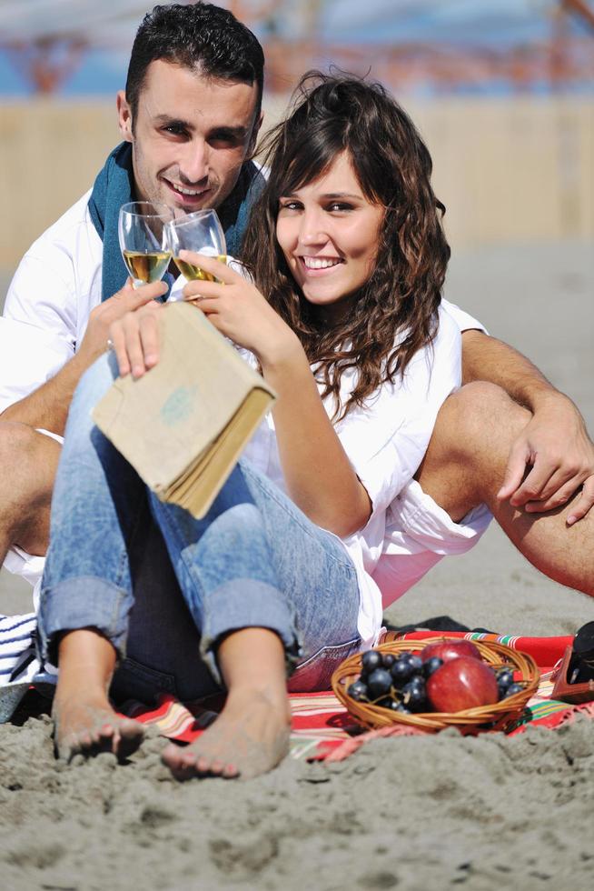 jeune couple profitant d'un pique-nique sur la plage photo