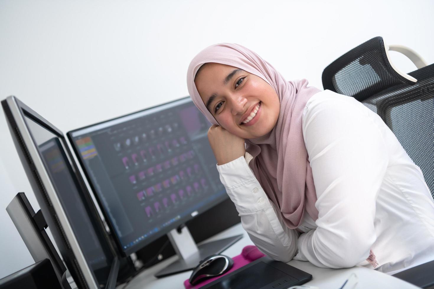 professionnelle créative arabe féminine travaillant au bureau à domicile sur un ordinateur de bureau avec vue de dessus de moniteur à double écran. mise au point sélective photo