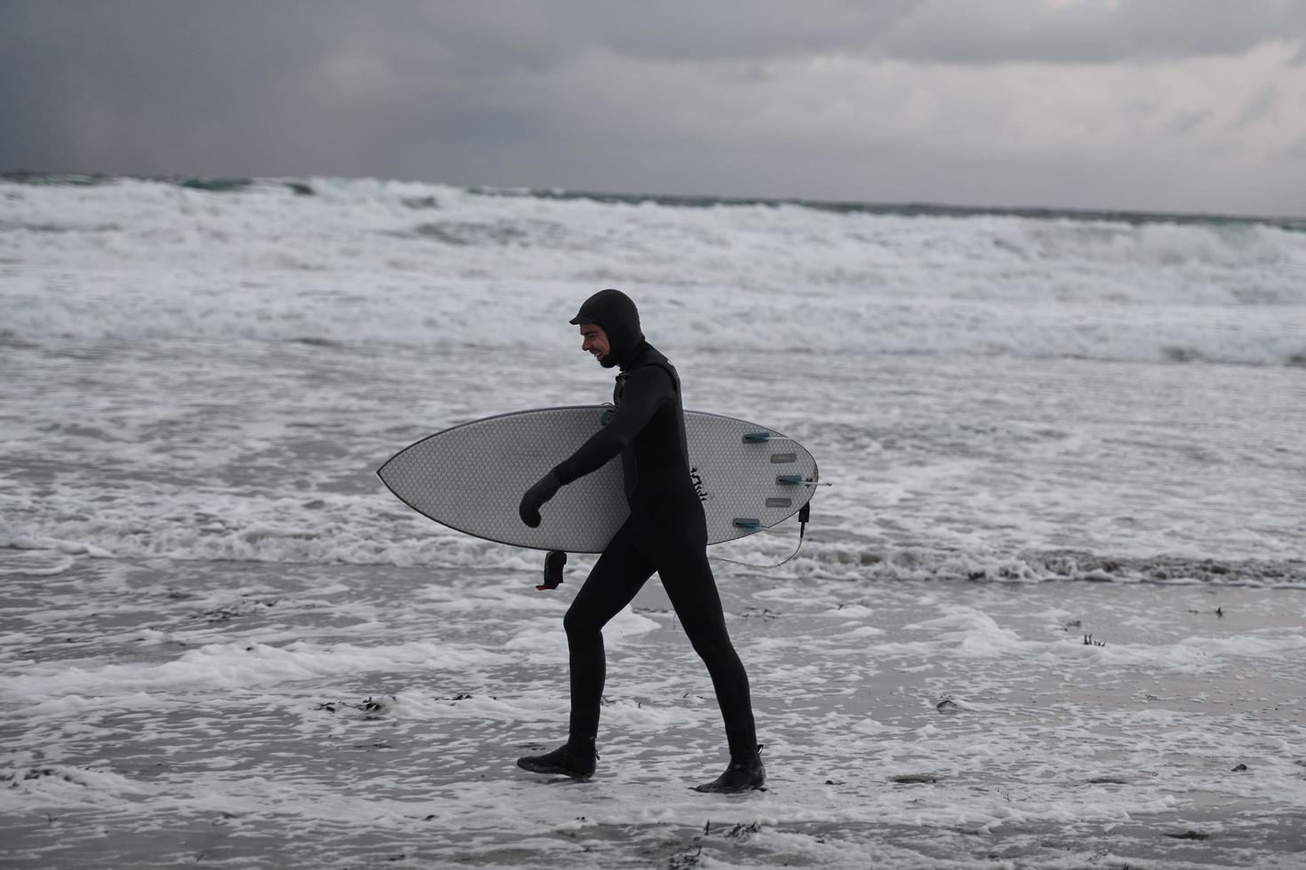 surfeur arctique passant par la plage après avoir surfé photo