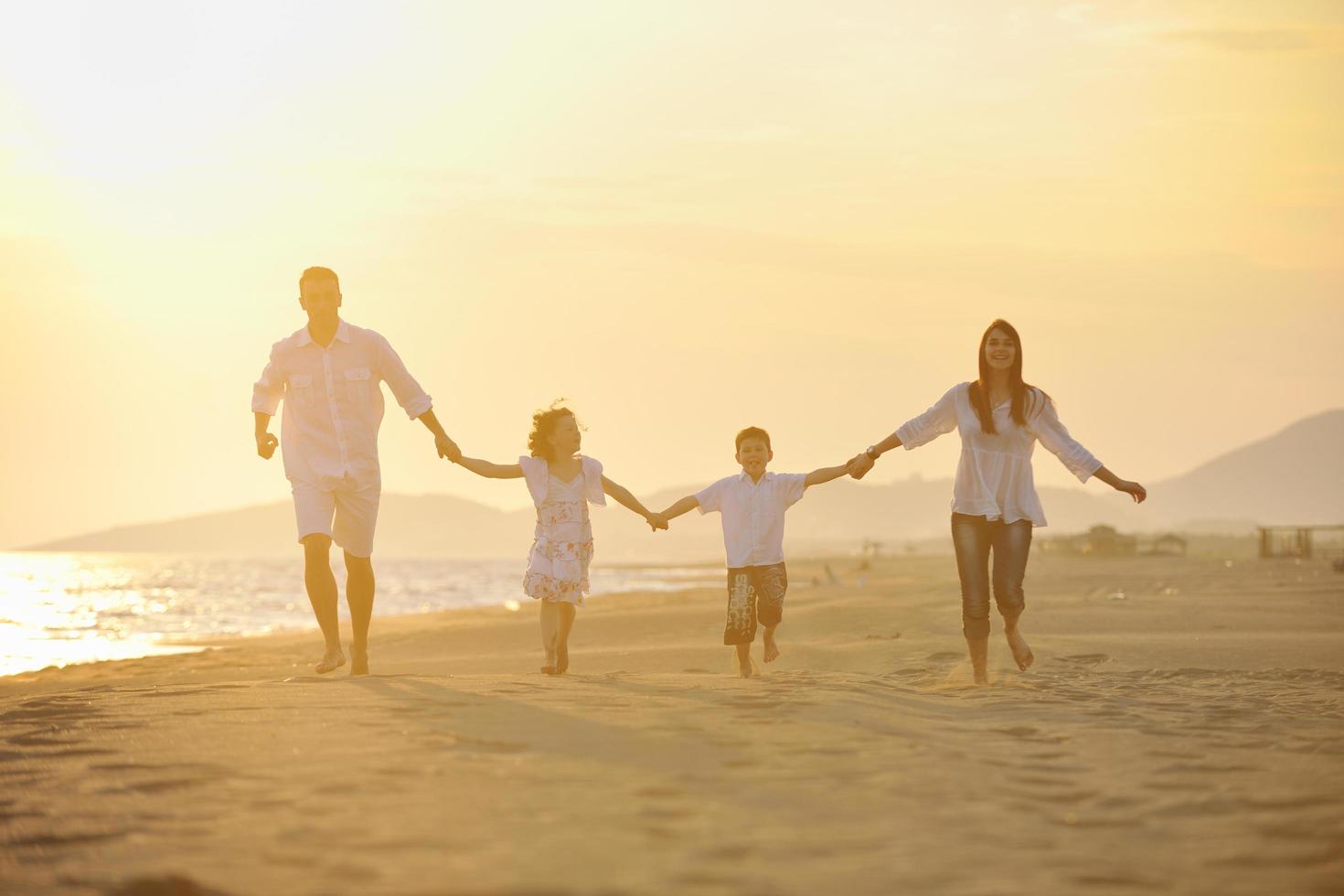 jeune famille heureuse s'amuser sur la plage photo