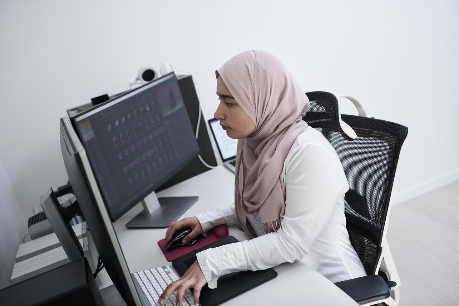 professionnel de la création arabe travaillant au bureau à domicile sur un ordinateur de bureau photo