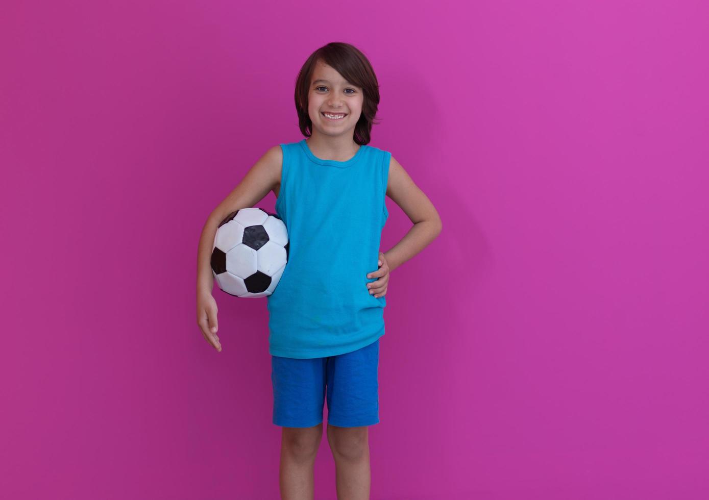 Garçon arabe avec ballon de foot sur fond rose photo