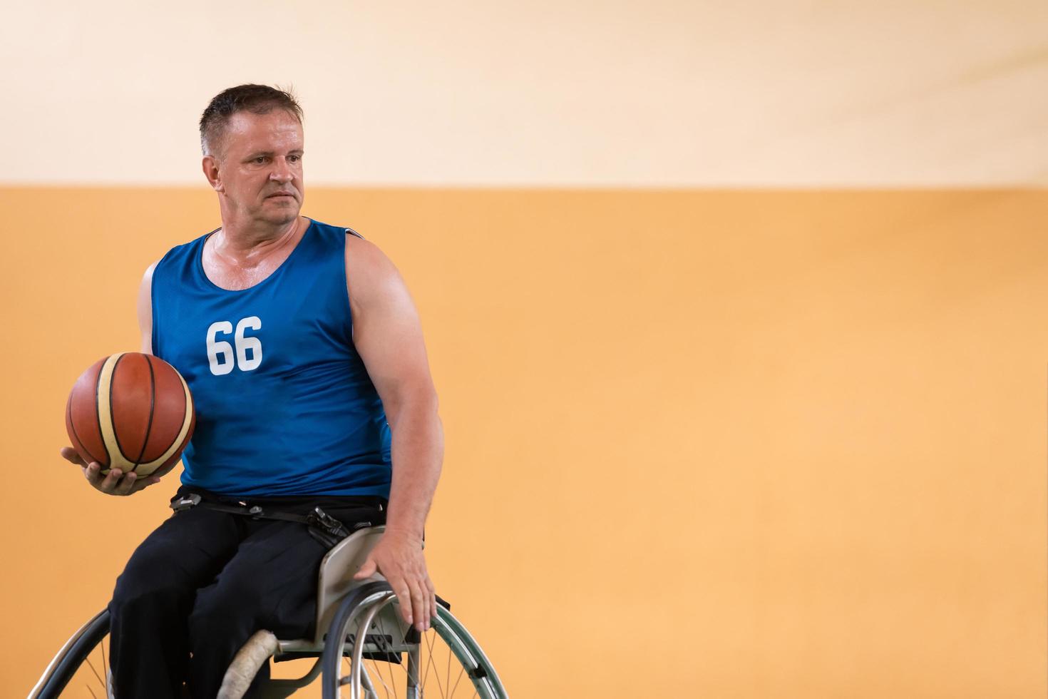 anciens combattants handicapés en action tout en jouant au basket-ball sur un terrain de basket avec des équipements sportifs professionnels pour les handicapés photo