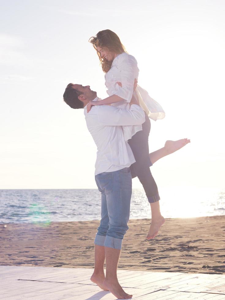 jeune couple sur la plage s'amuser photo