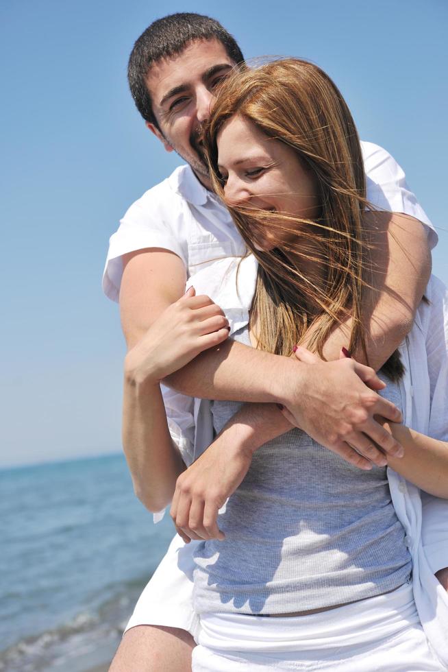 heureux jeune couple s'amuser sur la plage photo