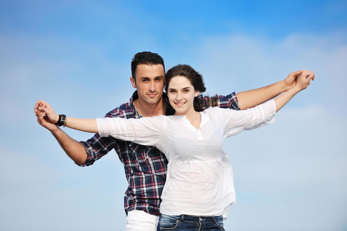 heureux jeune couple s'amuser sur la plage photo