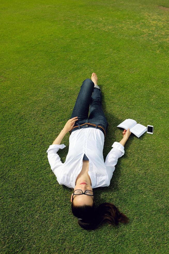 jeune femme lisant un livre dans le parc photo