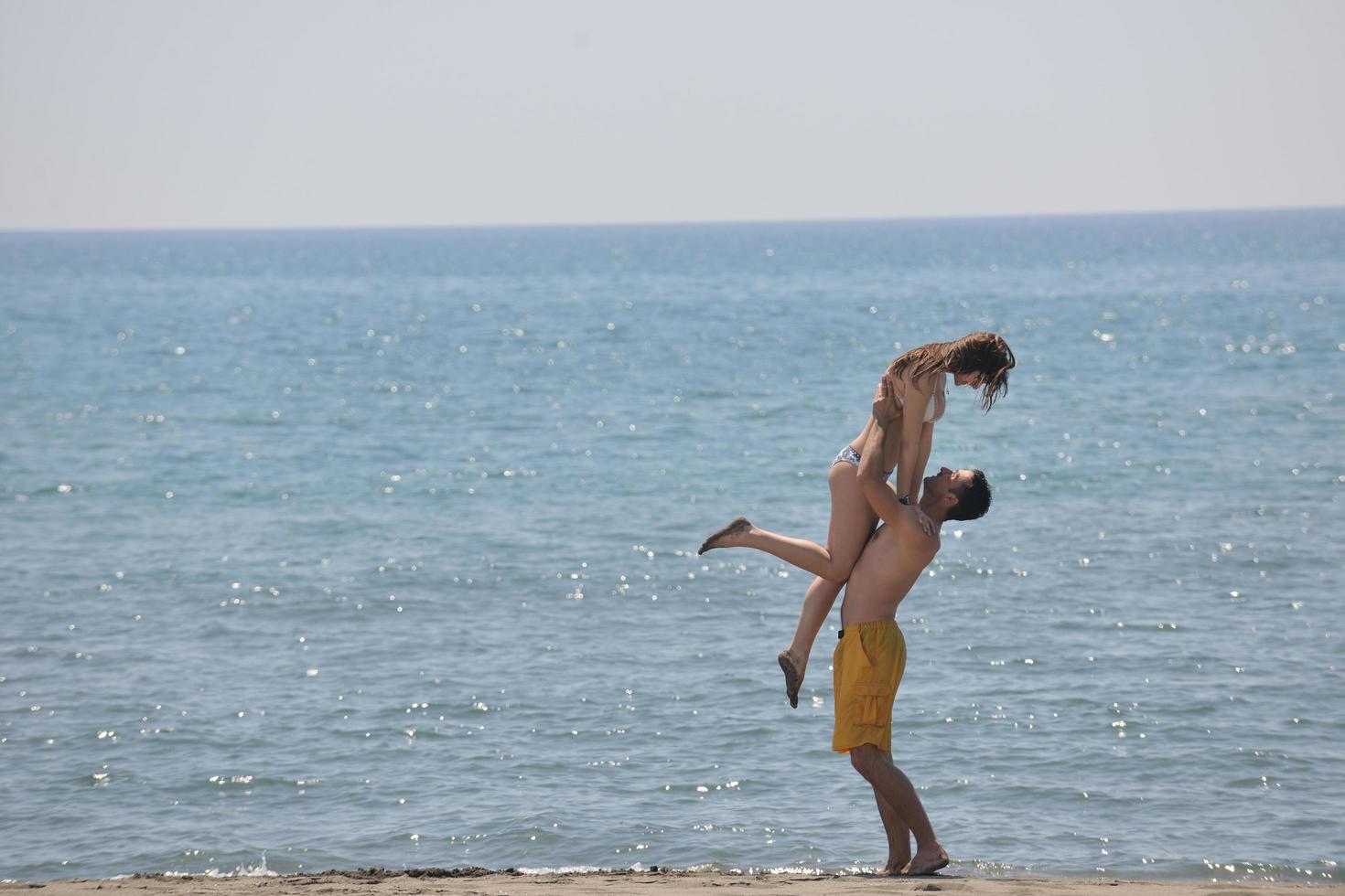 heureux jeune couple s'amuser sur la plage photo