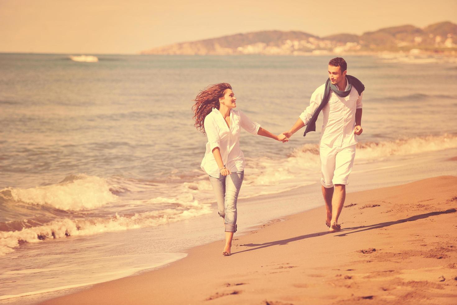 heureux jeune couple s'amuser sur la belle plage photo