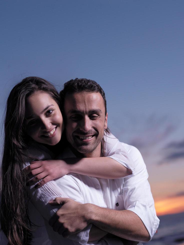 jeune couple sur la plage s'amuser photo