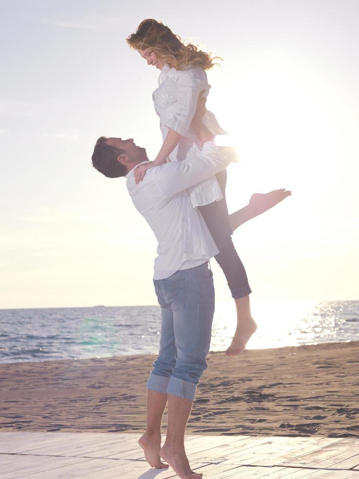 jeune couple sur la plage s'amuser photo