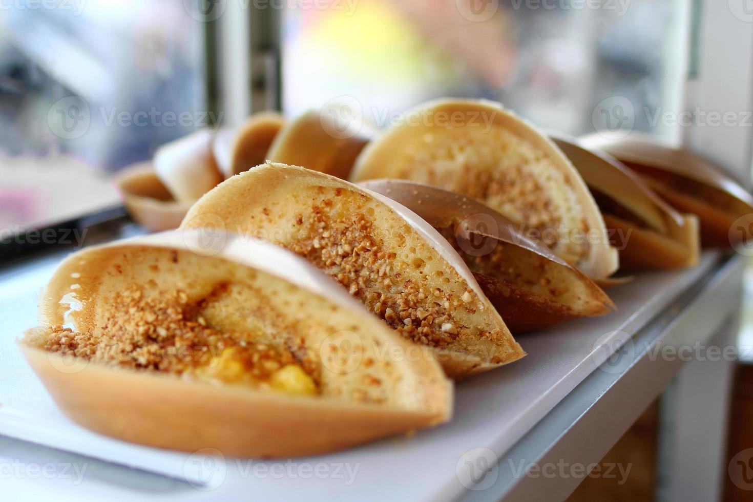 cuisine de rue malaisienne traditionnelle apam balik - crêpe molle épaisse avec cacahuètes, bananes, beurre de cacahuète et maïs sucré. marché de rue à georgetown, malaisie. photo