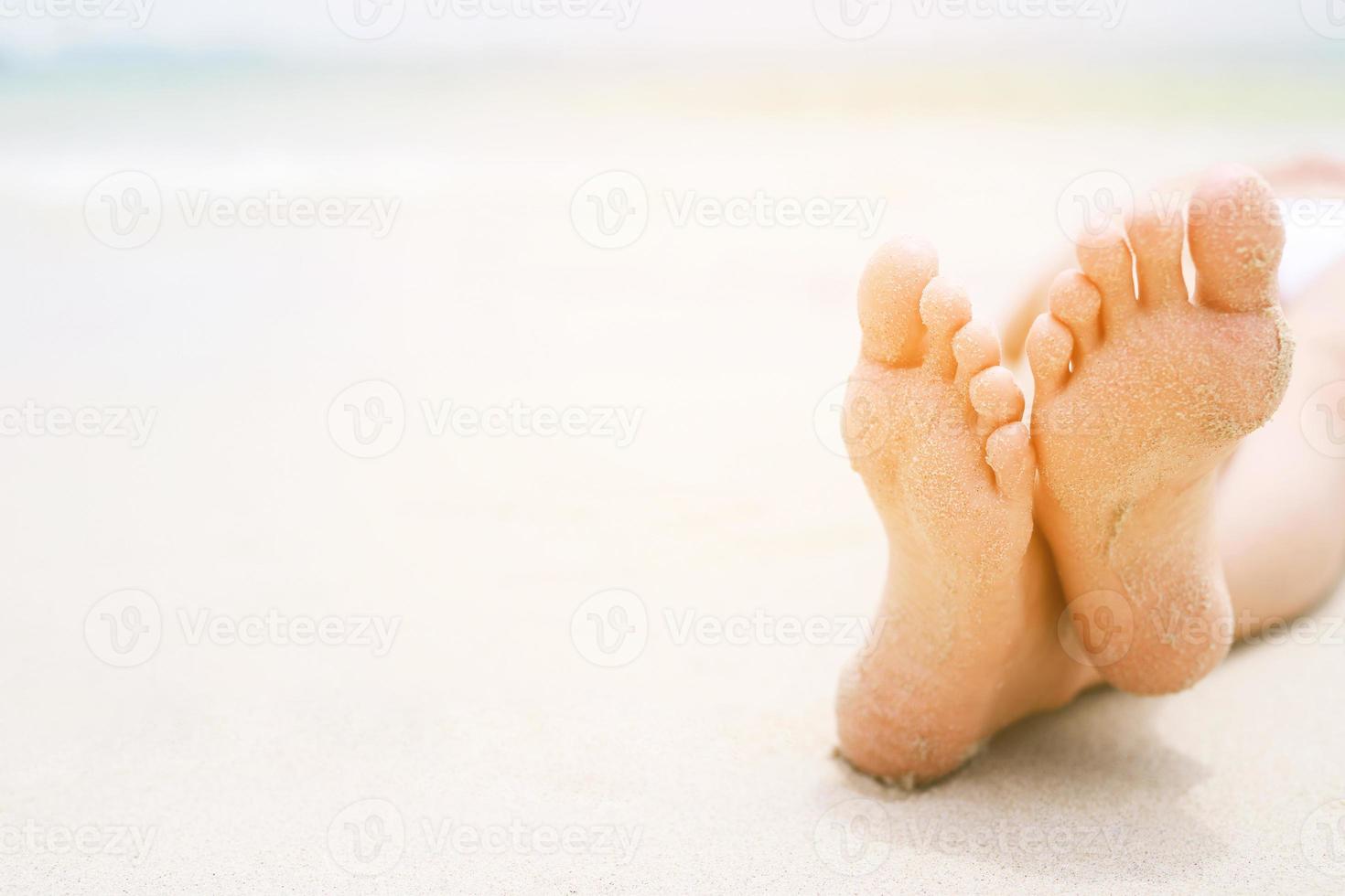 Bronzage jeune femme bronzée en bikini portant des chapeaux de paille allongé sur une plage tropicale sur du sable blanc qui s'étend jusqu'à la jambe mince photo