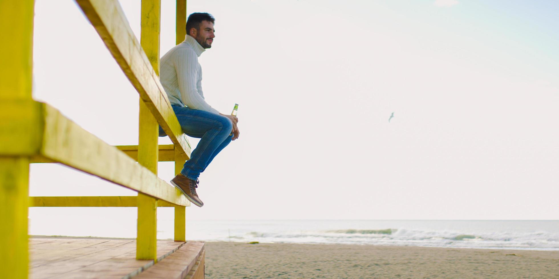 homme buvant de la bière à la plage photo