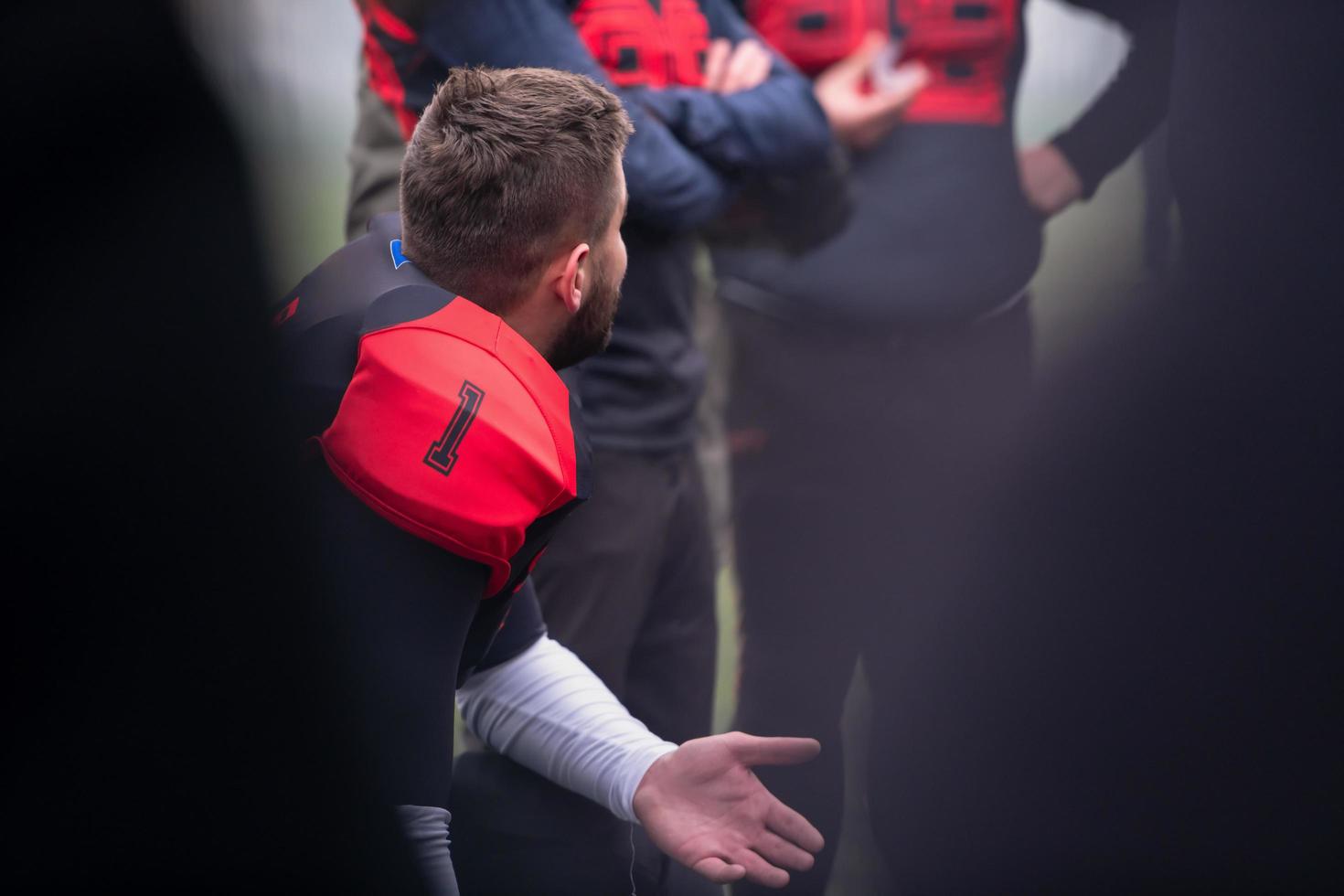 joueur de football américain discutant de stratégie avec son équipe photo