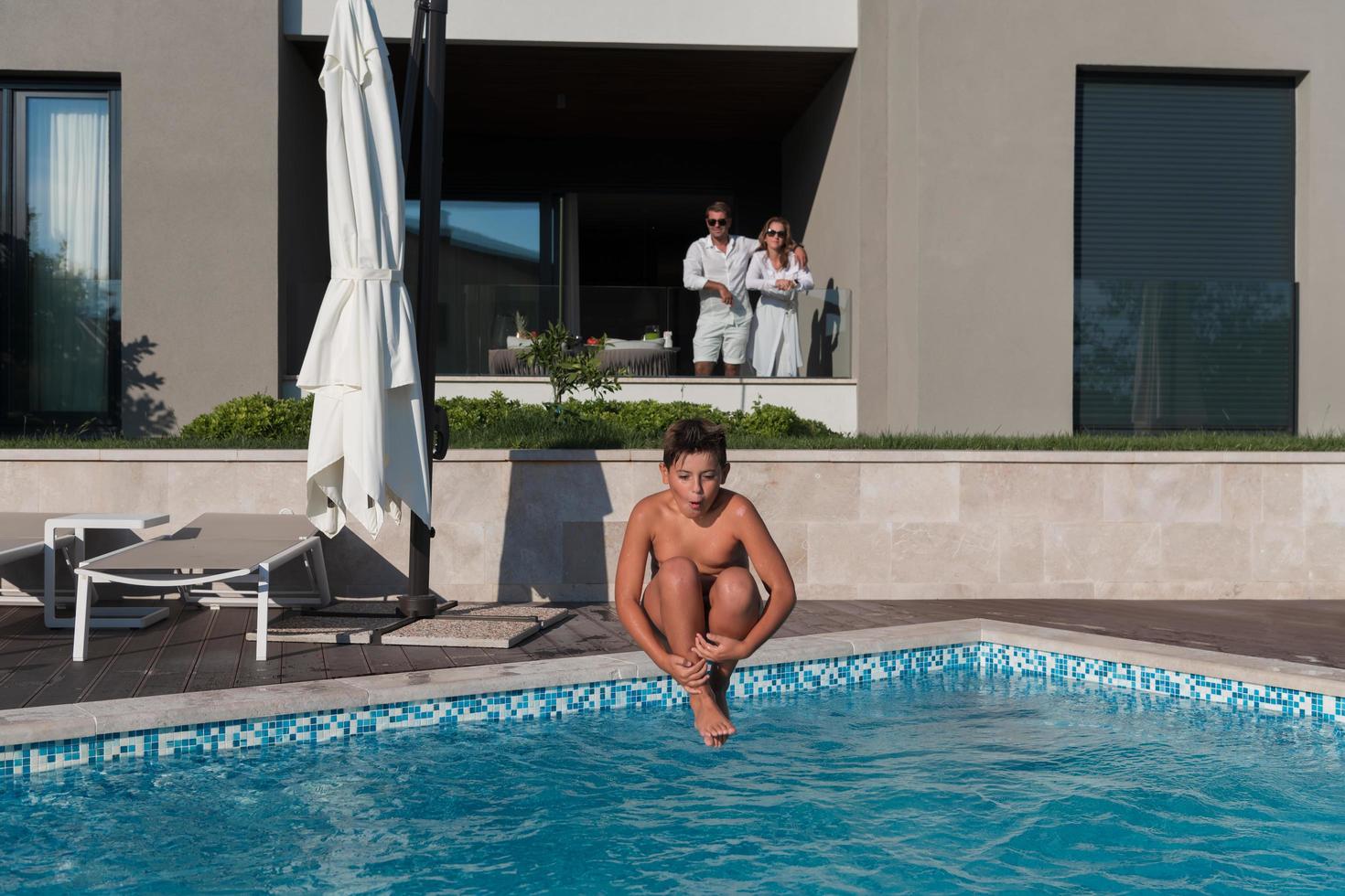 une famille heureuse profite de vacances dans une maison de luxe avec piscine. un couple de personnes âgées passe du temps avec leur fils pendant les vacances. mise au point sélective photo