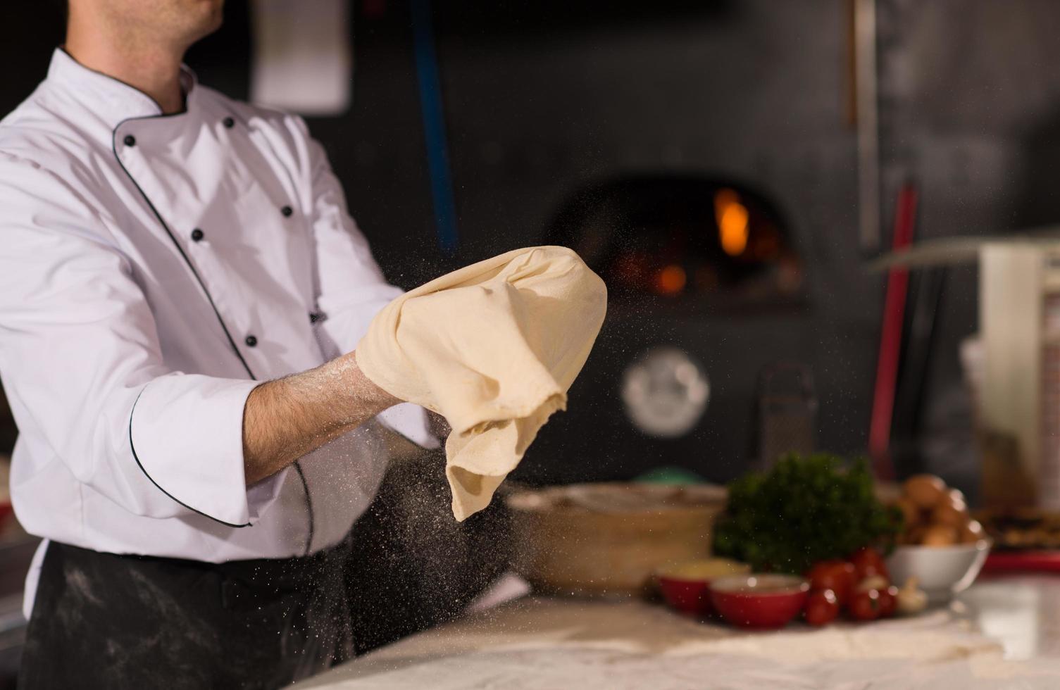 chef vomissant de la pâte à pizza photo