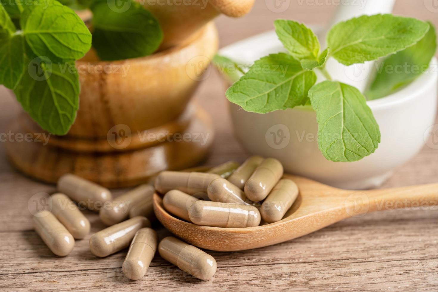 capsule biologique à base de plantes de médecine alternative avec vitamine e oméga 3 huile de poisson, minéral, médicament avec feuilles d'herbes suppléments naturels pour une bonne vie saine. photo