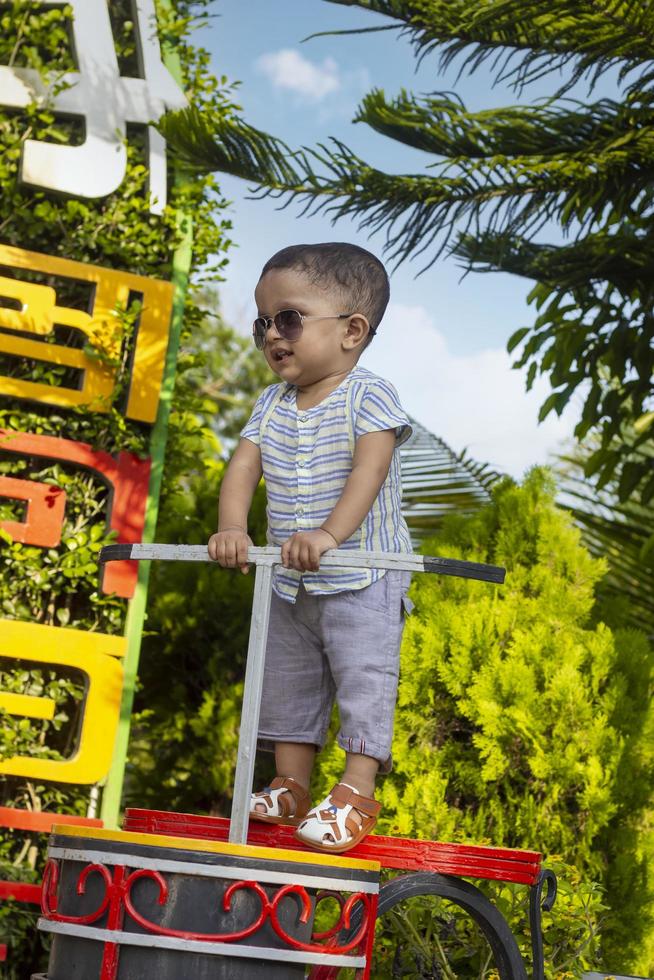 enfant debout dans le parc, petit garçon souriant debout dans le parc photo