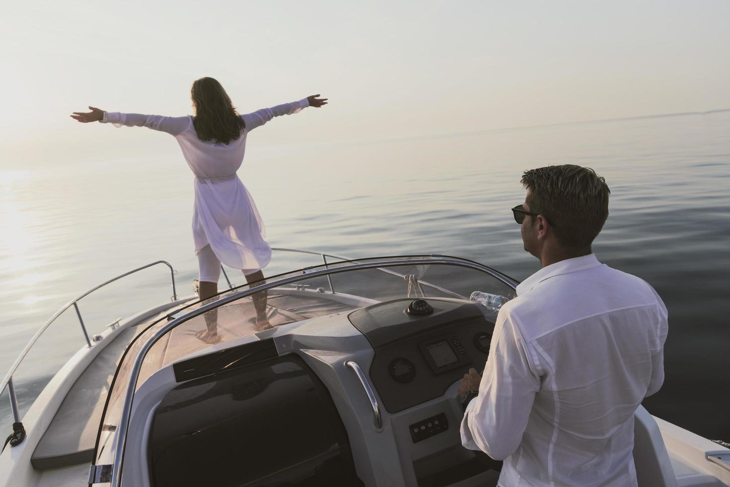 un couple de personnes âgées en tenue décontractée avec leur fils profite d'un bateau en mer au coucher du soleil. le concept d'une famille heureuse. mise au point sélective photo