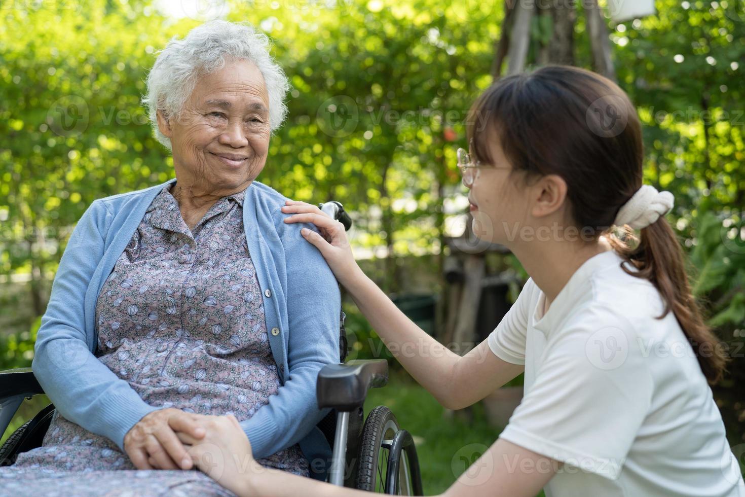 soignant aide et soins asiatique senior ou âgée vieille dame patiente assise sur un fauteuil roulant dans le parc, concept médical fort et sain. photo