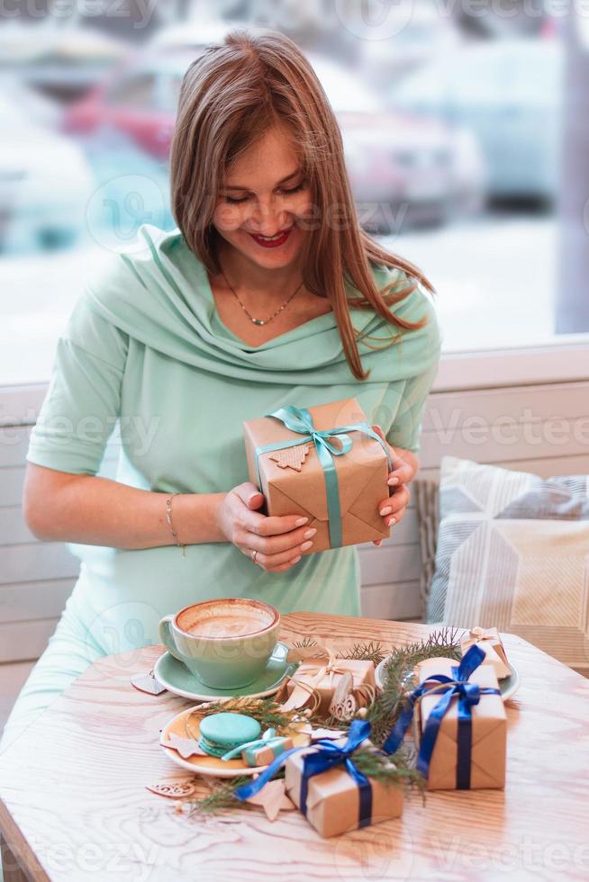 jeune femme enceinte souriante au café avec une tasse de café et