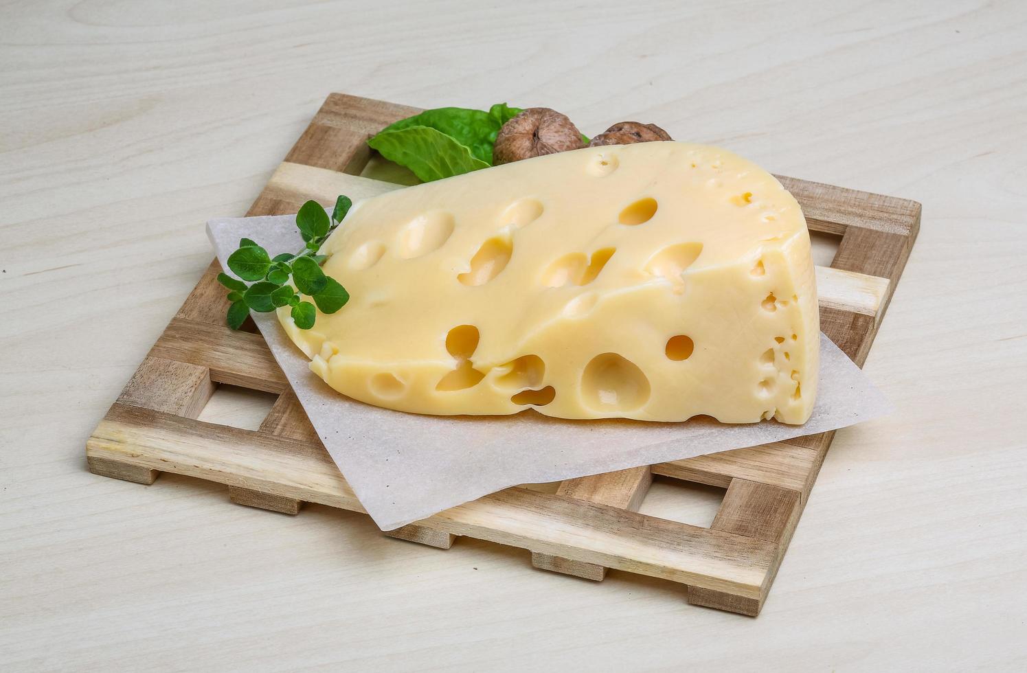 Fromage jaune sur planche de bois et fond de bois photo