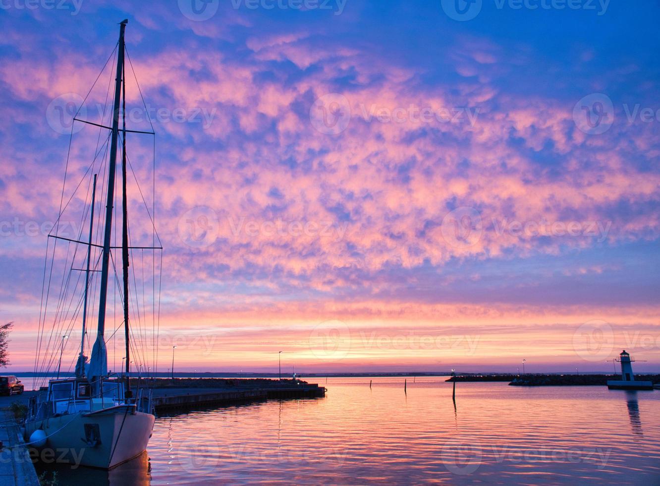 voilier dans le port du lac vaettern au coucher du soleil. phare en arrière-plan photo