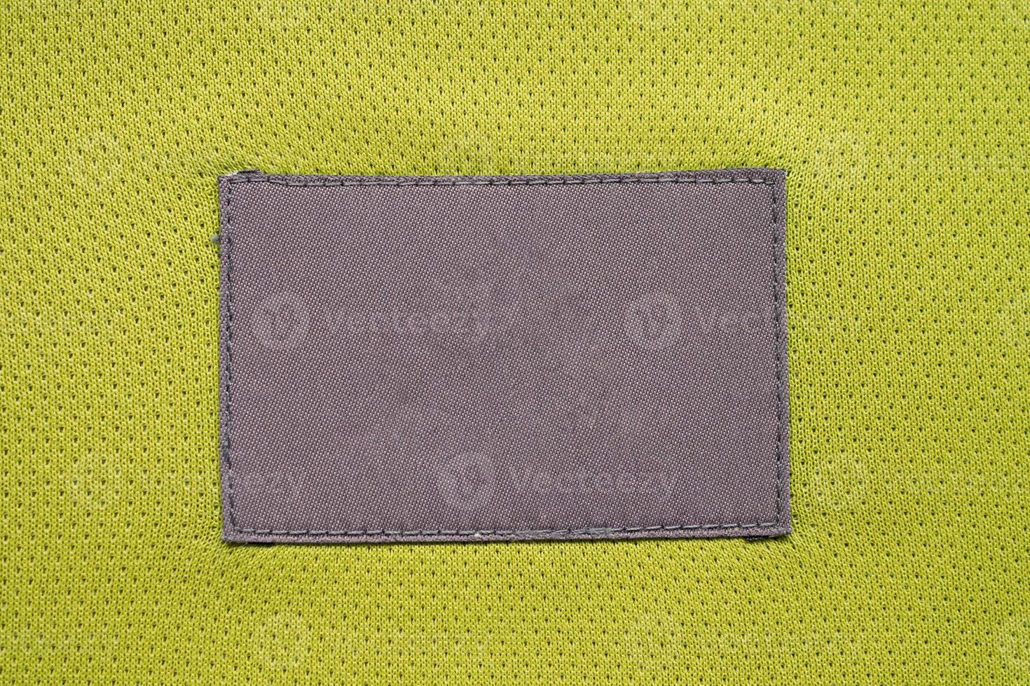 Patch d'étiquette de vêtements d'entretien du linge sur la texture de sport de jersey de tissu de polyester photo