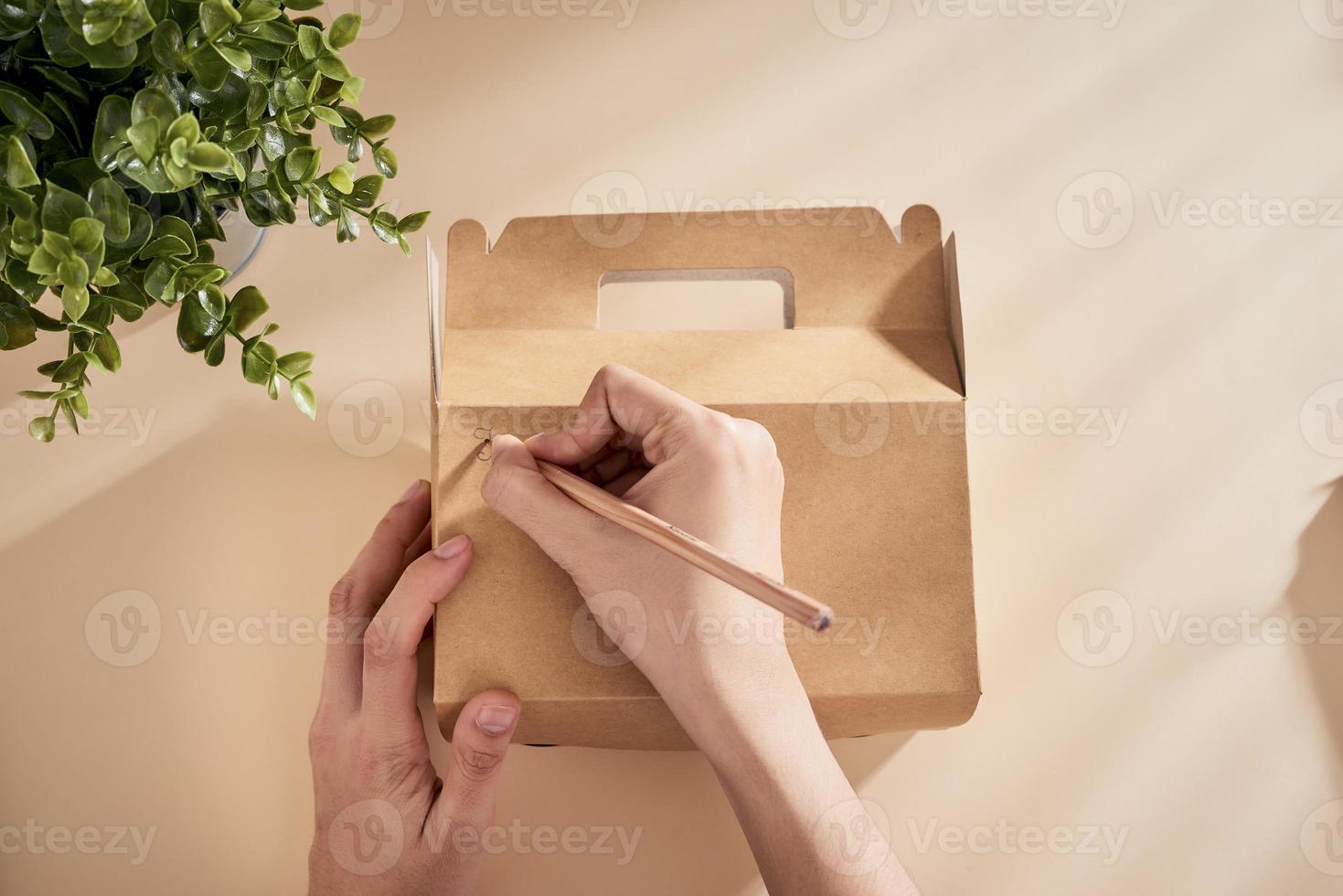 image recadrée d'une femme écrivant ses meilleurs voeux sur une boîte avec un présent photo