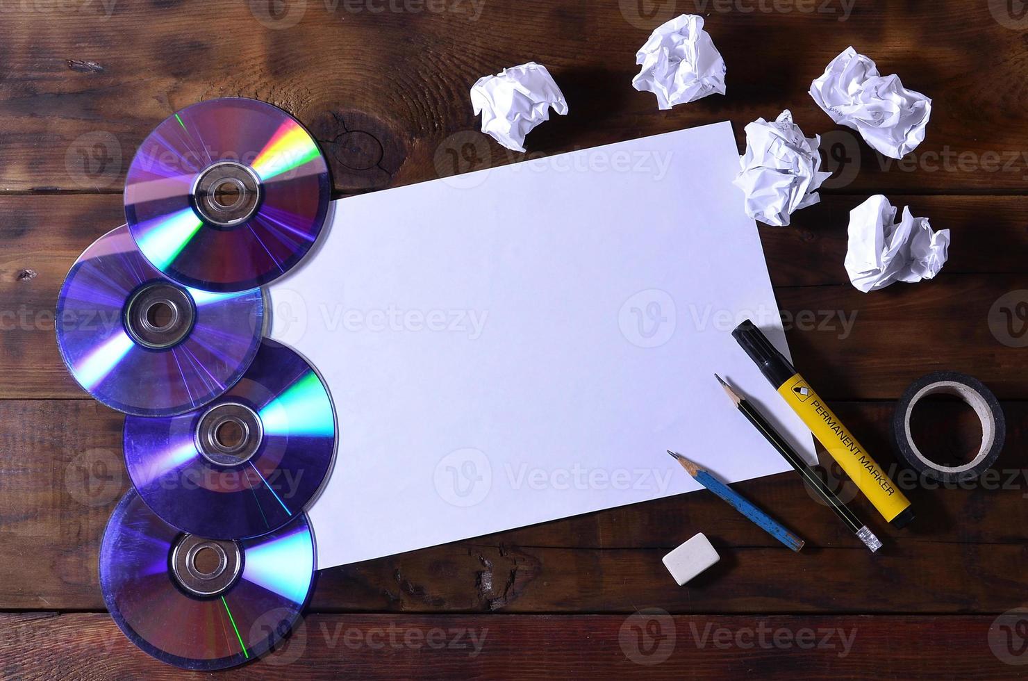 une école ou un bureau nature morte avec une feuille de papier vierge blanche et de nombreuses fournitures de bureau. les fournitures scolaires se trouvent sur un fond en bois marron. place pour le texte photo