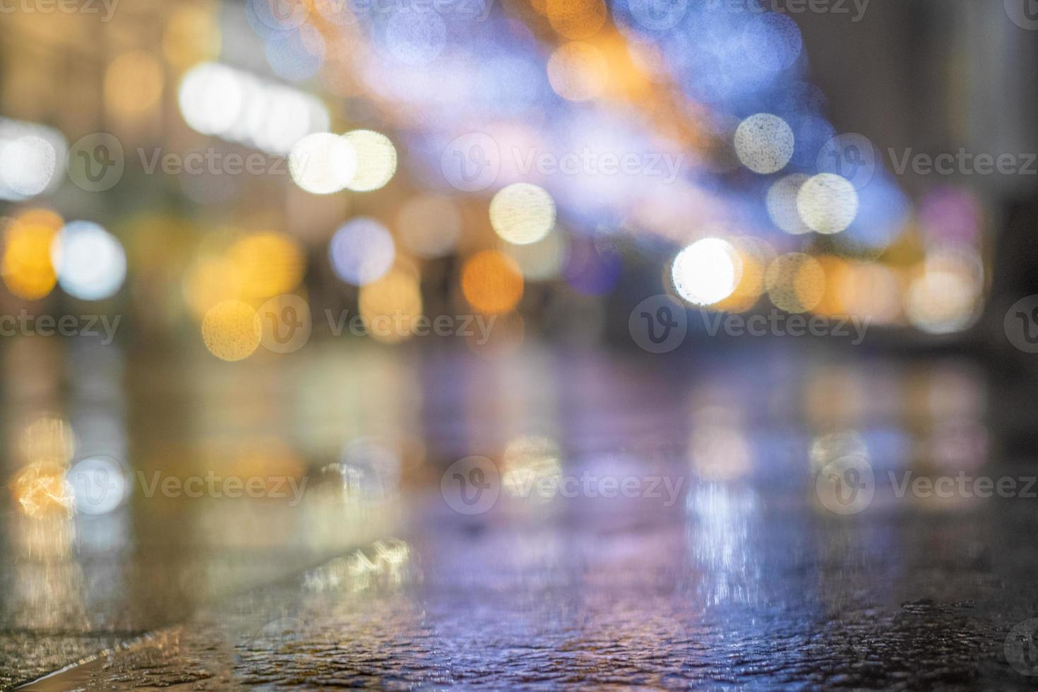 paysage urbain de nuit, lumières colorées reflétées dans l'asphalte humide à l'automne. rue de nuit pluvieuse dans la ville. les lumières d'une nuit pluvieuse dans la ville d'automne du flou et du bokeh. rue des néons. photo