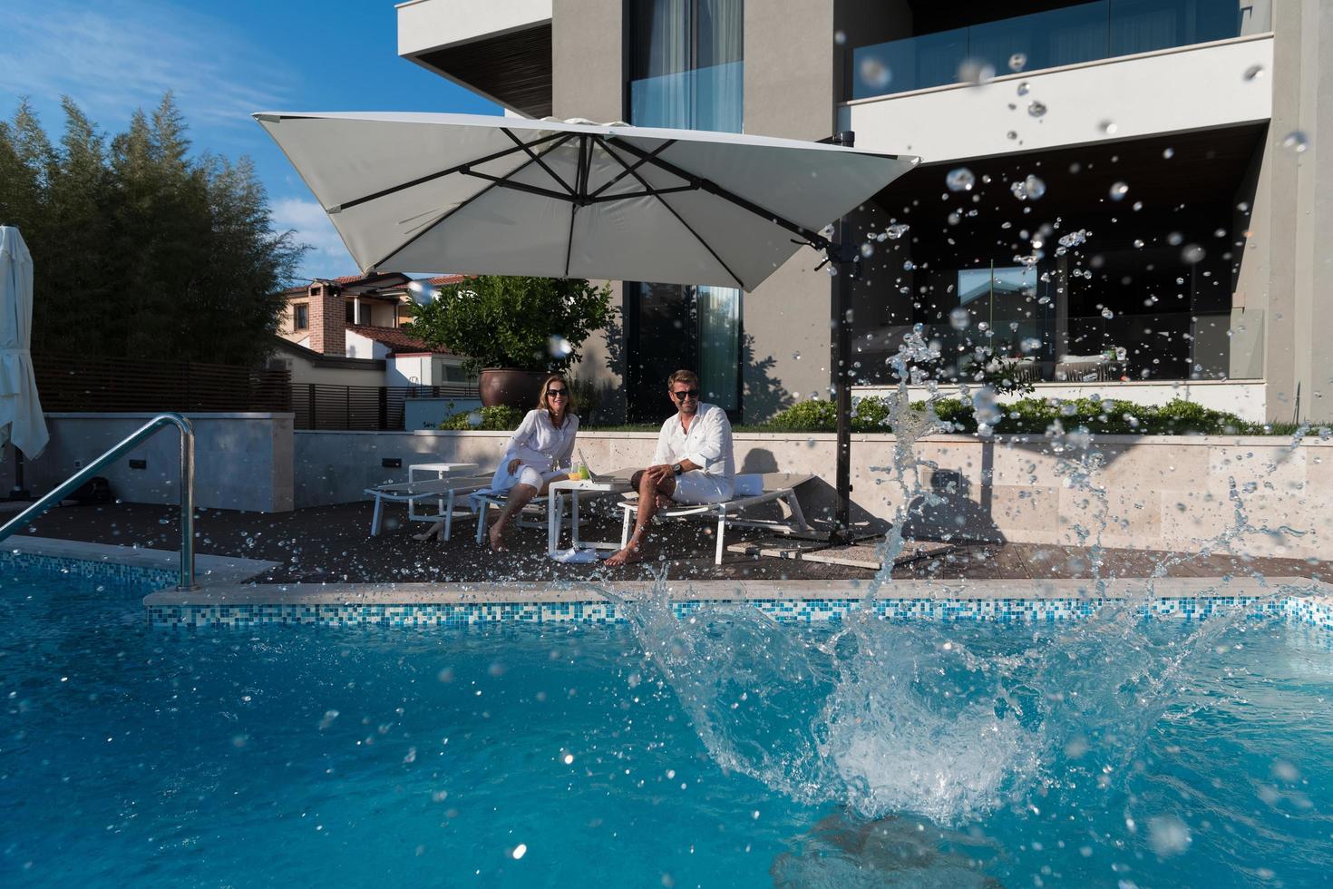 une famille heureuse profite de vacances dans une maison de luxe avec piscine. un couple de personnes âgées passe du temps avec leur fils pendant les vacances. mise au point sélective photo