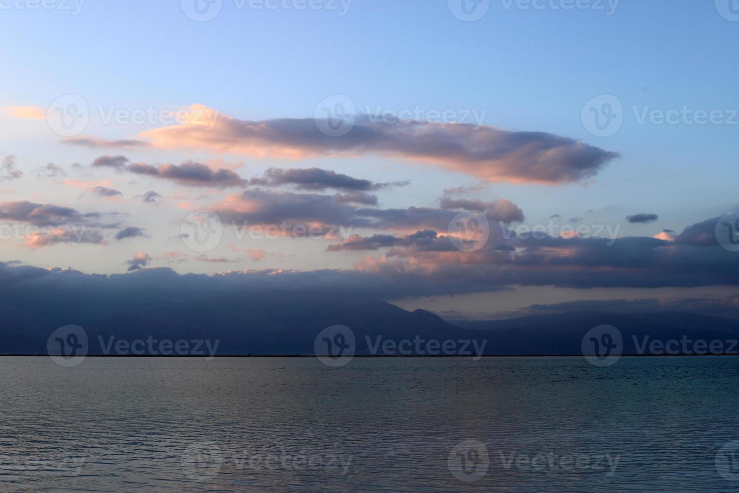 lever de soleil sur le rivage de la mer morte en israël. le soleil se lève derrière les montagnes en jordanie. photo