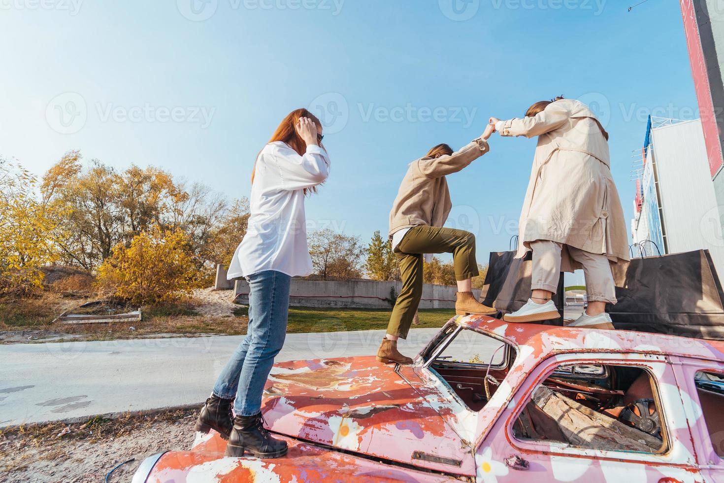 une jeune femme est debout dans une voiture avec des sacs à la main photo