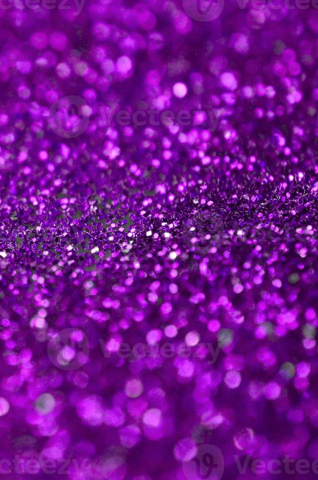 paillettes décoratives violettes. image de fond avec des lumières bokeh brillantes à partir de petits éléments photo